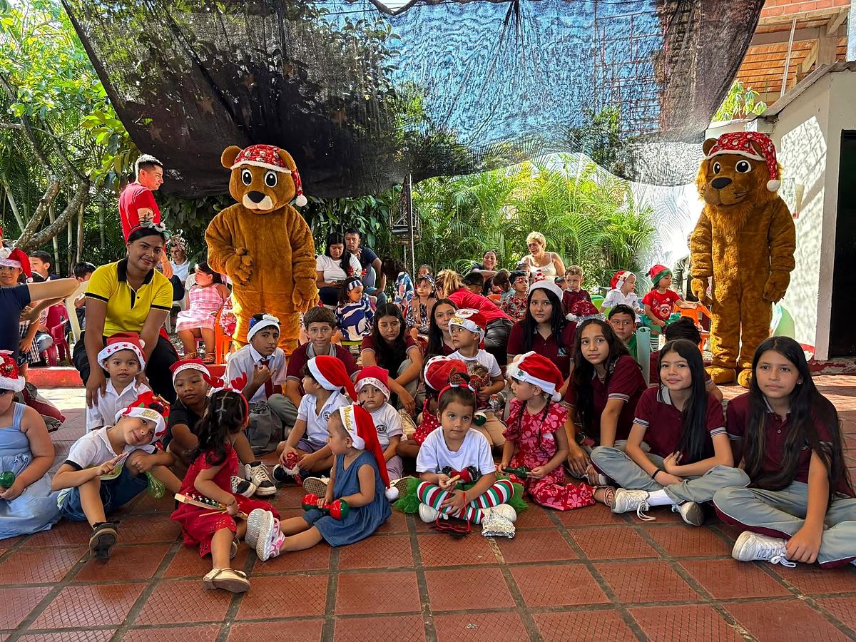 Estudiantes con gorros navideños junto a las mascotas del colegio