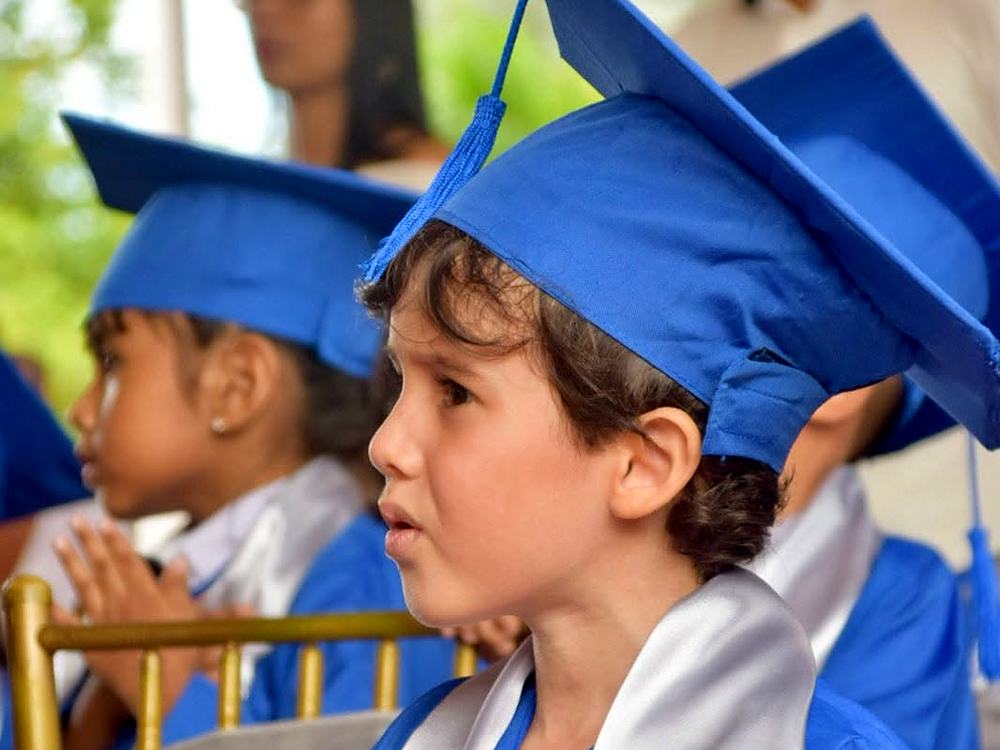 Estudiante de preescolar con toga azul en su ceremonia de grado