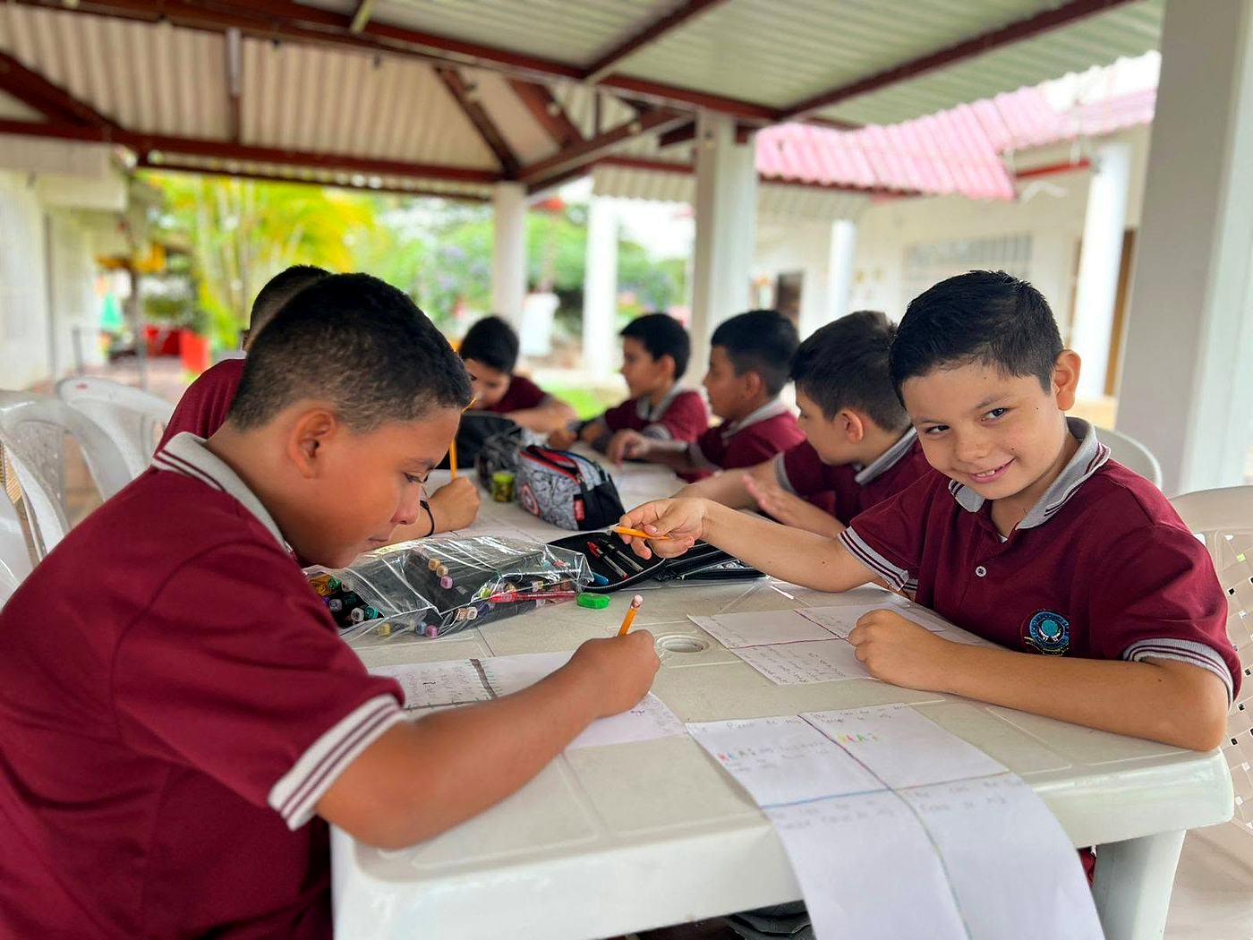 Estudiantes de primaria trabajando en una clase al aire libre